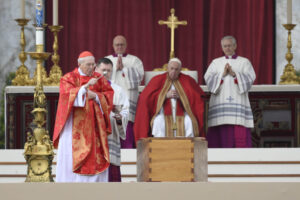 Cardinal Giovanni Battista Re sprinkles holy water on the casket of Pope Benedict XVI as Pope Francis looks on during the late pope's funeral Mass in St. Peter's Square at the Vatican Jan. 5, 2023. (CNS photo/Vatican Media)